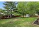 This backyard features a grass lawn, a swing set, a shed, a patio set, and a wood fence at 8218 San Carlos Ct, Indianapolis, IN 46256