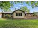 Spacious backyard with well-maintained brick home, large windows, wood deck, and mature trees at 8218 San Carlos Ct, Indianapolis, IN 46256