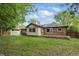 Well-maintained brick home featuring a wooden deck, green lawn, and mature trees in the backyard at 8218 San Carlos Ct, Indianapolis, IN 46256