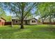 Spacious backyard with well-maintained brick home, wood deck, swing set, and mature trees at 8218 San Carlos Ct, Indianapolis, IN 46256