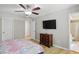 Bedroom featuring a ceiling fan, mounted TV, dresser and access to the bathroom at 8218 San Carlos Ct, Indianapolis, IN 46256