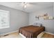 Comfortable bedroom featuring a window, ceiling fan, and minimalist decor at 8218 San Carlos Ct, Indianapolis, IN 46256