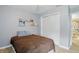 A cozy bedroom featuring light grey walls, a built-in closet, and light wood-style flooring at 8218 San Carlos Ct, Indianapolis, IN 46256