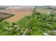 Elevated view showcasing the property, encompassed by mature trees, agricultural zones, and neighboring homes near a road at 8293 Water St, Coatesville, IN 46121