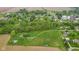 An aerial view of the land, revealing a large parcel with a road leading towards trees and a cluster of houses at 8293 Water St, Coatesville, IN 46121