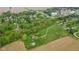 Aerial view of the parcel, featuring tree-lined boundaries and a road, with a backdrop of homes and agricultural fields at 8293 Water St, Coatesville, IN 46121