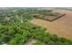Overhead shot displaying the property, enhanced by verdant trees, farm fields, and nearby houses along a peaceful road at 8293 Water St, Coatesville, IN 46121