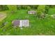 The aerial view captures multiple buildings amid an overgrown field, revealing potential at 8293 Water St, Coatesville, IN 46121