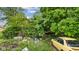 Lush backyard featuring a weathered house, overgrown foliage, car, and various items scattered about at 8293 Water St, Coatesville, IN 46121
