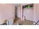 Small bedroom with pink paneled walls, standard carpeting, a closet, and minimal furnishings at 8293 Water St, Coatesville, IN 46121