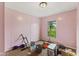 An empty bedroom with pink paneled walls, basic carpeting, and a window providing natural light at 8293 Water St, Coatesville, IN 46121