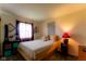 Simple bedroom featuring soft yellow walls, a neutral bed, and a red accent lamp for a warm ambiance at 8362 Punto Alto Dr, Indianapolis, IN 46227