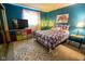 Cozy bedroom with blue walls, patterned rug, colorful storage, and a bed with floral comforter at 8362 Punto Alto Dr, Indianapolis, IN 46227