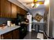 Efficient kitchen with dark wood cabinets, black appliances, and a stacked washer/dryer for convenience at 8362 Punto Alto Dr, Indianapolis, IN 46227