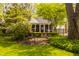 Landscaped backyard with a brick patio and lush foliage around the screened-in porch and home at 8770 N Pennsylvania St, Indianapolis, IN 46240