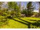 Spacious backyard with a lush lawn, a storage shed, mature trees, and a decorative bird bath at 8770 N Pennsylvania St, Indianapolis, IN 46240