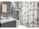 Well decorated bathroom with blue walls, marble vanity, and decorative shower curtain at 8770 N Pennsylvania St, Indianapolis, IN 46240