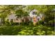 Charming two-story home featuring a brick facade, white trim, blue shutters, and a well-manicured lawn with mature trees at 8770 N Pennsylvania St, Indianapolis, IN 46240
