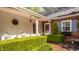 Inviting front porch with white columns, brick accents, trimmed bushes, and seating at 8770 N Pennsylvania St, Indianapolis, IN 46240
