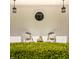 Charming front porch featuring vintage chairs, decorative lighting, and manicured boxwood hedges at 8770 N Pennsylvania St, Indianapolis, IN 46240