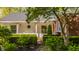 Beautiful front facade and porch area features brick and white paneling and manicured bushes and trees at 8770 N Pennsylvania St, Indianapolis, IN 46240