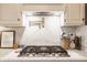 Modern kitchen featuring a stainless steel stove with granite countertops and light backsplash at 8770 N Pennsylvania St, Indianapolis, IN 46240