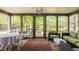 Enclosed sunroom with brick floor, lots of windows and comfortable seating with views of outdoor space at 8770 N Pennsylvania St, Indianapolis, IN 46240