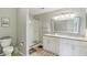 Bright bathroom with a glass shower, double vanity, and modern lighting at 8910 Hunters Creek Dr # 207, Indianapolis, IN 46227