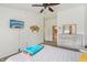 Bright bedroom with a ceiling fan, ensuite bathroom, TV, and dresser at 8910 Hunters Creek Dr # 207, Indianapolis, IN 46227