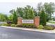 Community entrance sign, Creekside Crossing, with mature landscaping on a sunny day at 8910 Hunters Creek Dr # 207, Indianapolis, IN 46227