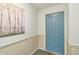 Condominium entrance featuring neutral walls, wainscoting and blue front door at 8910 Hunters Creek Dr # 207, Indianapolis, IN 46227