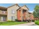 Inviting condominium exterior with manicured lawn, beautiful shrubs, and brick entryway at 8910 Hunters Creek Dr # 207, Indianapolis, IN 46227