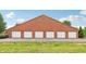 Exterior view of a brick multi-car garage with white doors at 8910 Hunters Creek Dr # 207, Indianapolis, IN 46227
