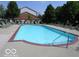 Large community swimming pool with chairs and view of community buildings on a sunny day at 8910 Hunters Creek Dr # 207, Indianapolis, IN 46227