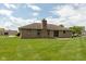 Rear exterior view of brick house with patio and large yard, perfect for outdoor living at 897 N Scott Dr, Greenwood, IN 46142
