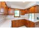 Kitchen with wooden cabinetry, a double basin sink, and a large window overlooking the backyard at 897 N Scott Dr, Greenwood, IN 46142