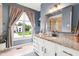 Stylish bathroom with a granite vanity, decorative mirror, and a large window showcasing the outdoor view at 9832 Scotch Pine Ln, Indianapolis, IN 46256