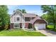 Charming two-story Tudor-style home with a brick and siding exterior, well-manicured lawn, and an attached two-car garage at 9832 Scotch Pine Ln, Indianapolis, IN 46256