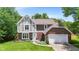 Charming two-story Tudor-style home with a brick and siding exterior, well-manicured lawn, and an attached two-car garage at 9832 Scotch Pine Ln, Indianapolis, IN 46256