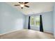 Comfortable bedroom featuring a ceiling fan, a neutral carpet, and an expansive window at 10412 Cedar Dr, Fishers, IN 46037