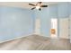 Spacious bedroom with light blue walls, neutral carpet, ceiling fan, and natural light at 10412 Cedar Dr, Fishers, IN 46037