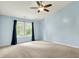 Comfortable bedroom featuring a ceiling fan, a neutral carpet, and an expansive window at 10412 Cedar Dr, Fishers, IN 46037