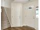 Home entryway featuring wood floors, and a staircase to the left. The front door has a decorative half circle window at 10412 Cedar Dr, Fishers, IN 46037