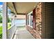 Inviting front porch featuring decorative hanging flowers, brick siding, and white railings at 10412 Cedar Dr, Fishers, IN 46037