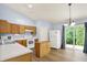 Bright kitchen with wood cabinets, white appliances, a center island, and sliding glass doors at 10412 Cedar Dr, Fishers, IN 46037