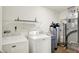 A laundry room with a washer, dryer, shelving, and water heater at 10412 Cedar Dr, Fishers, IN 46037