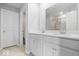 Bright bathroom featuring double sinks with white cabinets and a large, well-lit mirror at 10419 Pronghorn Ln, Indianapolis, IN 46239