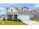 Charming two-story home with blue siding, white trim, covered porch, landscaped yard, and attached two-car garage at 10419 Pronghorn Ln, Indianapolis, IN 46239