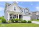 Charming two-story home with blue siding, white trim, covered porch, landscaped yard, and attached two-car garage at 10419 Pronghorn Ln, Indianapolis, IN 46239
