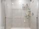Modern shower with glass doors and tiled walls with installed shelving at 10419 Pronghorn Ln, Indianapolis, IN 46239